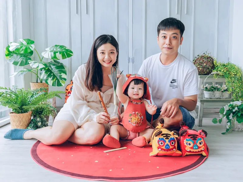 抓周完成後,爸媽和寶貝在紅色抓周墊上一起合照