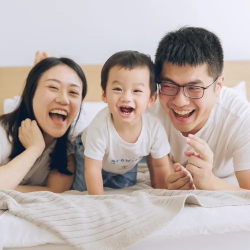 一家三口一起趴在床上大笑