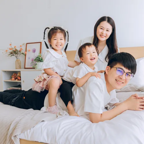 兩個寶貝坐在爸爸背上，媽媽在後面陪著